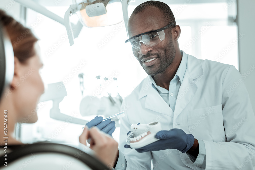 Dark-skin African American dentist having ordinary appointment Dark-skin African American dentist having ordinary appointment