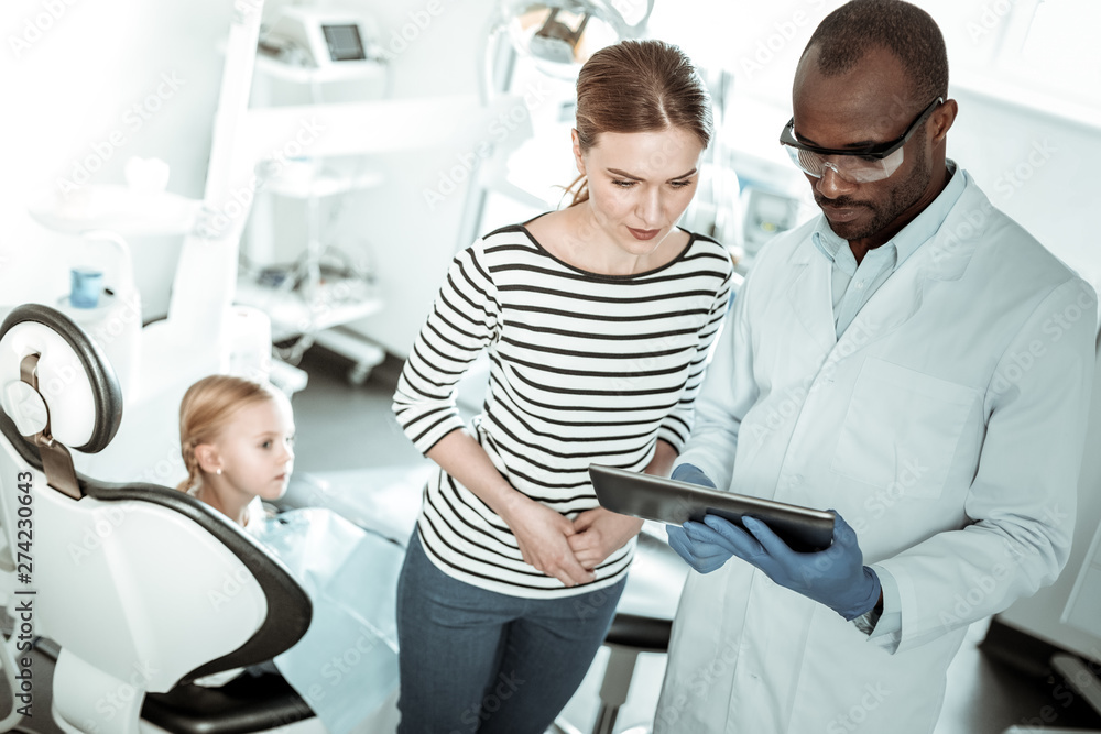 Obraz premium Executive stomatologist holding tablet and showing results