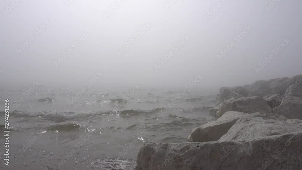 Fog and rocks long waters edge with waves crashing on shore. Fog and rocks long waters edge with waves crashing on shore.