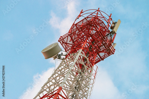 Wireless Communication Antenna Transmitter. Telecommunication tower with antennas on blue sky background.