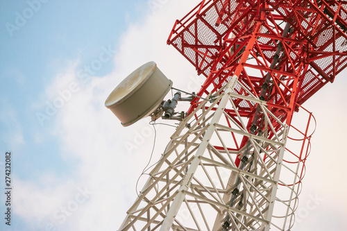 Wireless Communication Antenna Transmitter. Telecommunication tower with antennas on blue sky background.