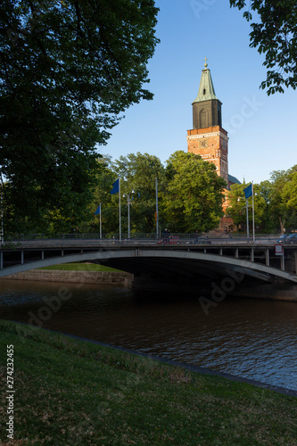Bridge over the river Auraioki and view of the historic 13th century cathedral in the city of Turko Abo on a summer day in Finland.