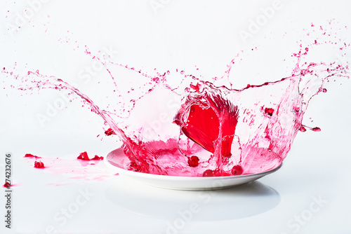 red cube of jelly falling and bouncing in red liquid photo