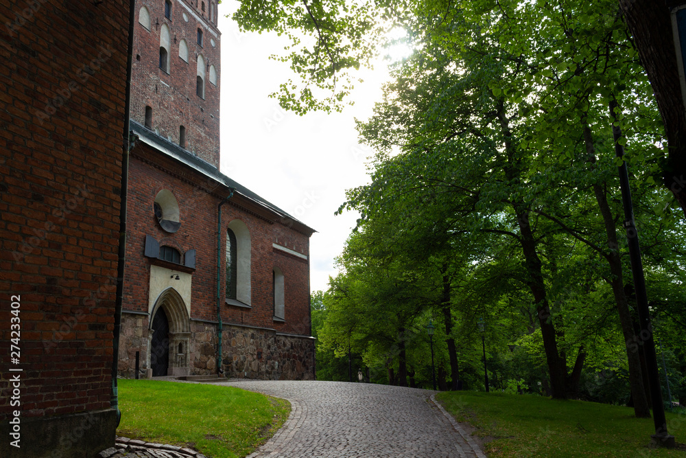 The walls of the historic Medieval Cathedral of the 13th century and the park around Turku Abo on a summer day in Finland.