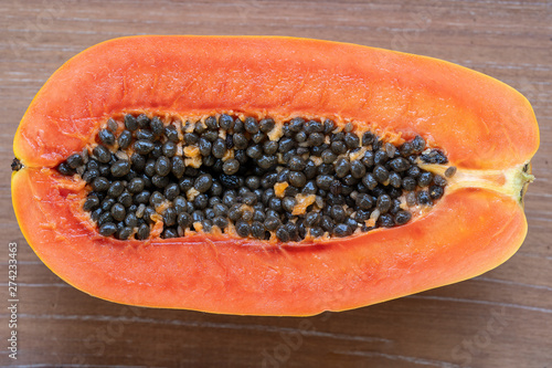 Half of ripe sweet papaya fruit with seeds background, closeup