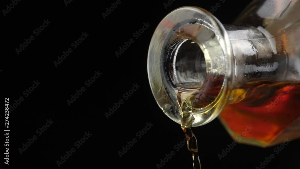 Whisky is poured into glass in slow motion Whisky is poured into glass in slow motion