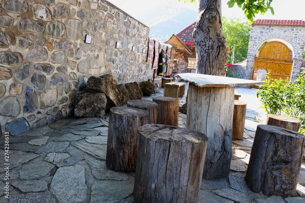 Wooden table and stools made from old timber logs. Natural chairs and tables for garden furniture made of stump logs.