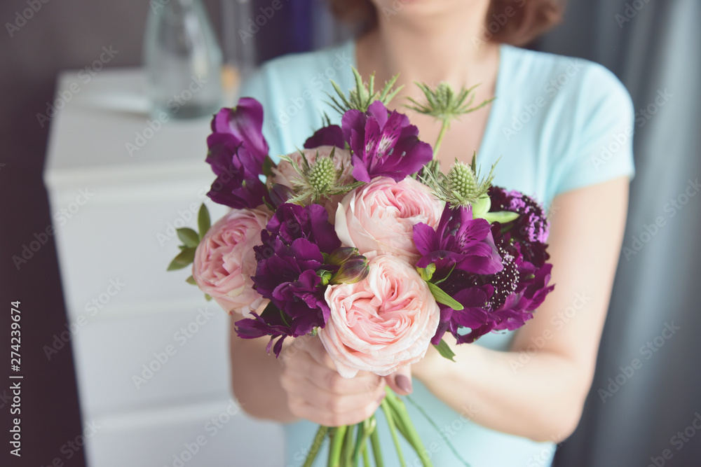 Florist finishes unusual bouquet of roses, alstroemeria, thorns and succulents. Flowers in female hands close up.