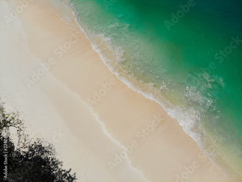 Top view blue sea with waves and soft sand beach background
