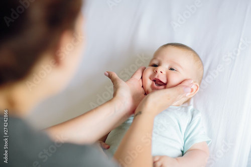 Mother playing with adorable happy baby