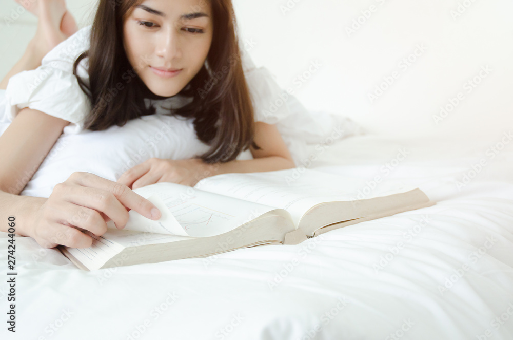 Women are reading books And she is having sleepiness And slept beside her book On the bed in the room.o not focus on the main object of this image.Copy space. Women are reading books And she is having sleepiness And slept beside her book On the bed in the room.o not focus on the main object of this image.Copy space.