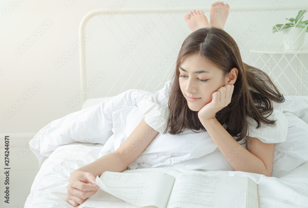 Women are reading books And she is having sleepiness And slept beside her book On the bed in the room.o not focus on the main object of this image.Copy space. Women are reading books And she is having sleepiness And slept beside her book On the bed in the room.o not focus on the main object of this image.Copy space.