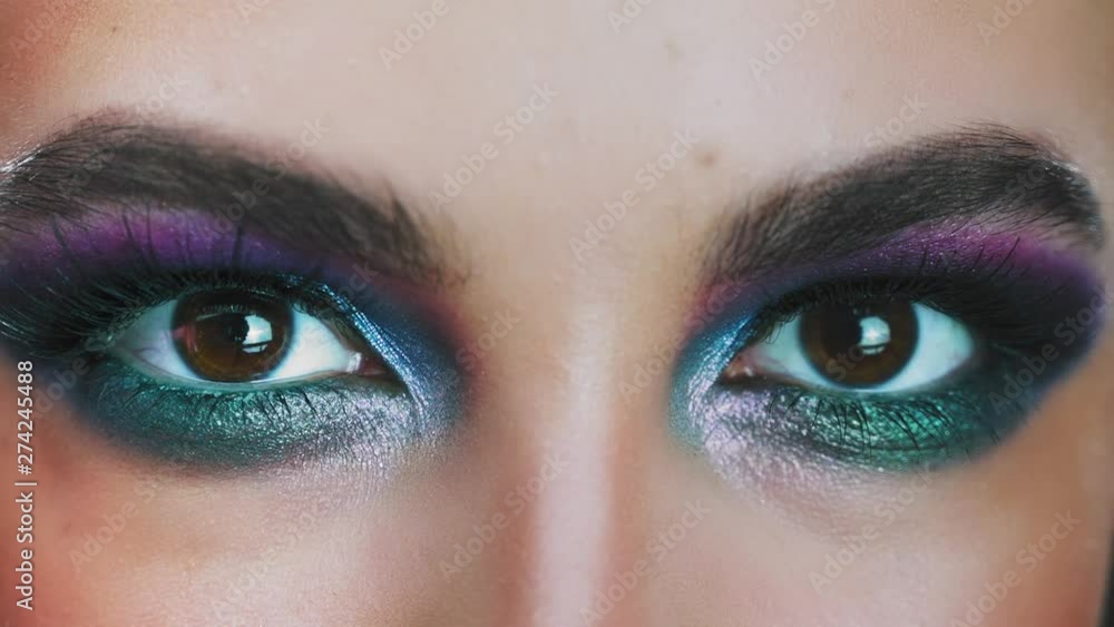 Amazing glance. Close up of caucasian woman eyes in glowing eyeshadows looking at camera. Fashion eyes makeup Amazing glance. Close up of caucasian woman eyes in glowing eyeshadows looking at camera. Fashion eyes makeup