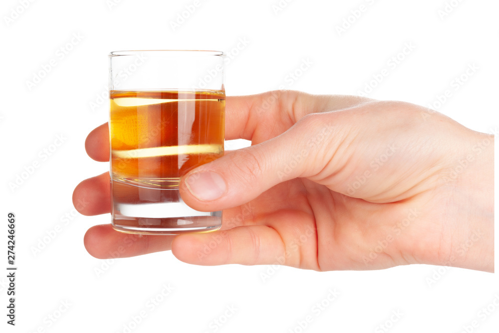 Man's hand holding a glass with tequila Man's hand holding a glass with tequila