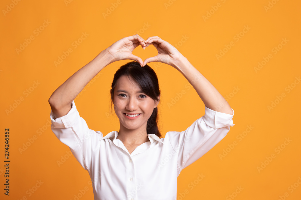 Young Asian woman gesturing heart hand sign. Young Asian woman gesturing heart hand sign.
