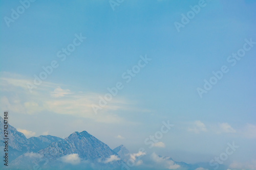 Sea view on peaks of Taurus Mountains covered by low clouds and fog from boat. Travel concept. Soft focus