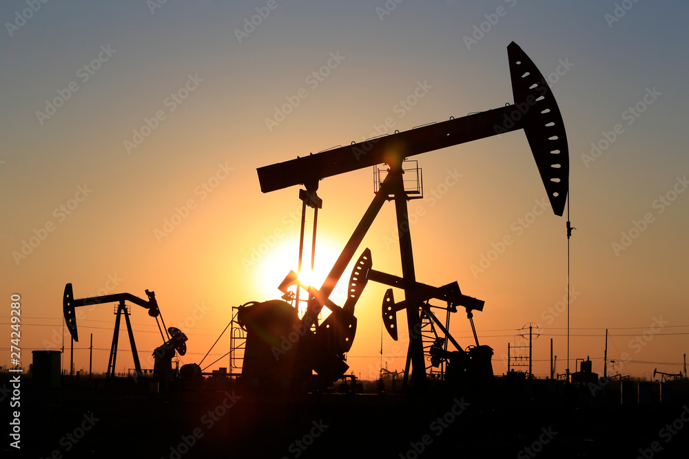 The pumping unit is working in the setting sun The pumping unit is working in the setting sun