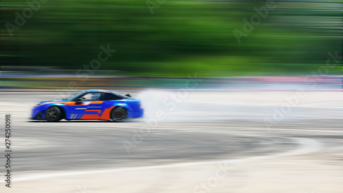 Sport car wheel drifting. Motion blurred of image diffusion race drift car with lots of smoke from burning tires on speed track.