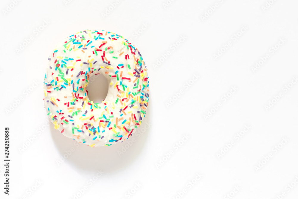 White frosted donut with colorful sprinkles on white background. White frosted donut with colorful sprinkles on white background.