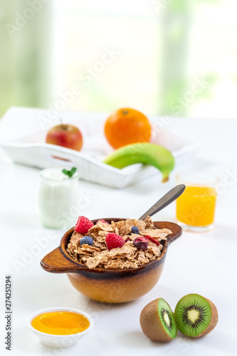 Healthy breakfast with bowl of cereal  orange juice  milk    and fruits on white background.