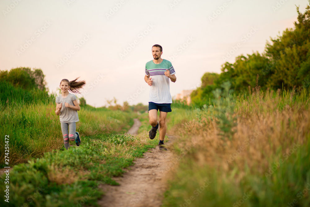Father and daughter jogging. Cheerful father and daughter run in park together. Sport life concept