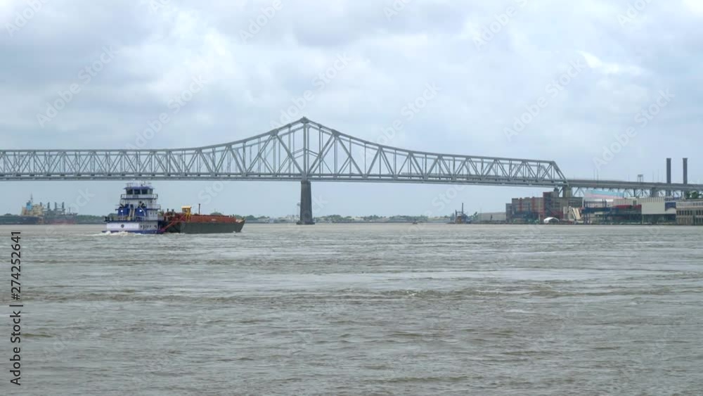 Beautiful landscape of the Mississippi River with a ferryboat and a bridge in the background. New Orleans USA. Flat plane Beautiful landscape of the Mississippi River with a ferryboat and a bridge in the background. New Orleans USA. Flat plane