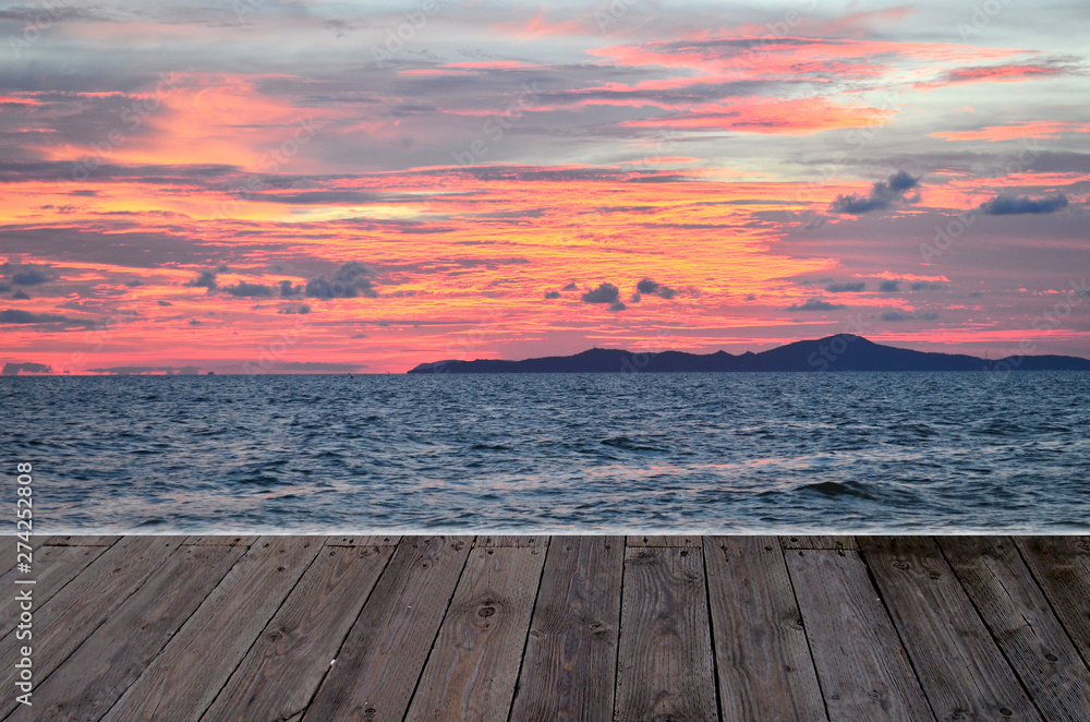 beautiful pink sunset twilight orange blue sky at sea with wooden table top texture concept romantic scenic