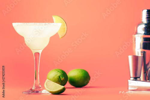Lime margarita alcoholic cocktail with silver tequila, liqueur, lime juice, sugar syrup, salt and ice, festive trendy pink background, copy space photo