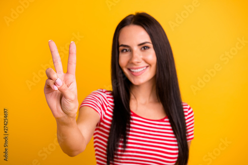 Close up photo of nice pretty cute attractive lady have vacation spring holidays feel rejoice dressed modern youth clothing isolated yellow vibrant background make v-signs © deagreez