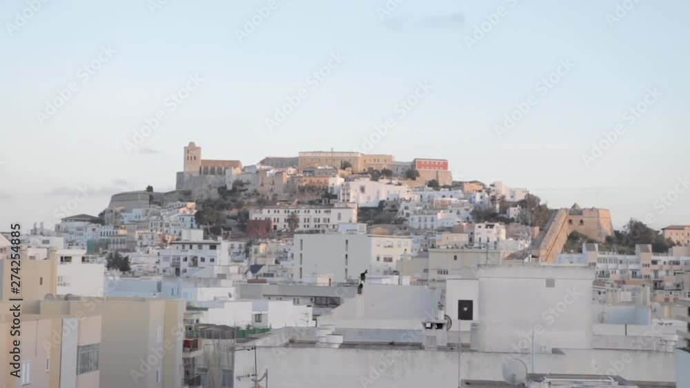 Panoramic landscape of Ibiza city with blue sky during Afternoon. Lot of buildings over the mountains.