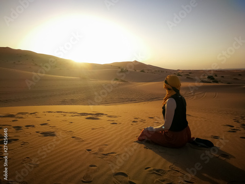 Woman on desert tour looking into sunset