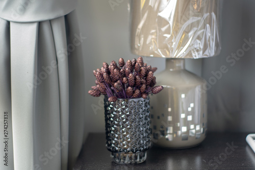Purple artificial flowers in clear crystal glass