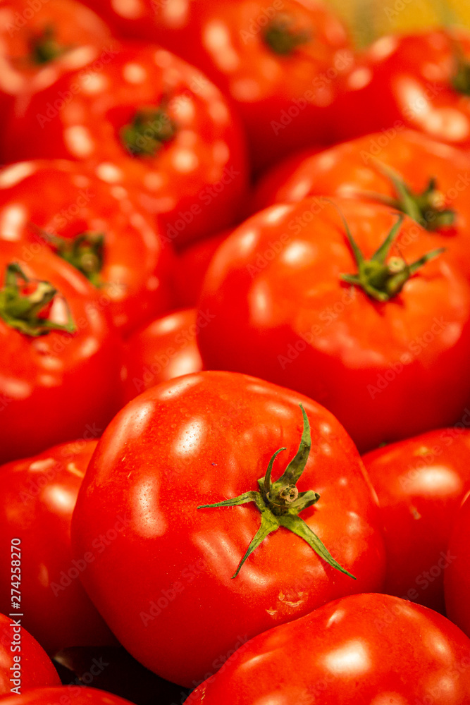 Bright red tomatoes on display at a farmers market stall