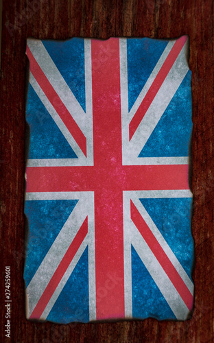 grungy burnt edges union jack flag on red wooden background