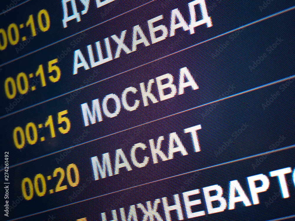 Electronic scoreboard flights and airlines. Destinations wrote in Russian language translate are: Ashgabat, Moscow, Muscat. Airport flight information arrival displayed on departure board, flight Electronic scoreboard flights and airlines. Destinations wrote in Russian language translate are: Ashgabat, Moscow, Muscat. Airport flight information arrival displayed on departure board, flight