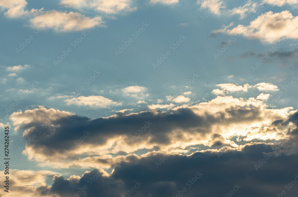 Blue sky at sunset with colorful clouds. Blue, yellow, white, gray and dark blue. Beautiful nature concept for design