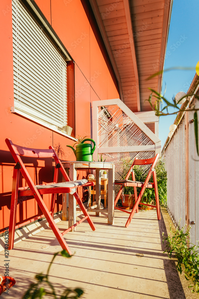 Cozy summer balcony: Red chairs, sunshine, nobody