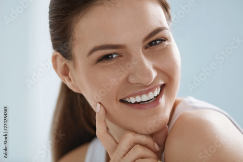 Smiling woman face with white teeth smile, clean skin portrait