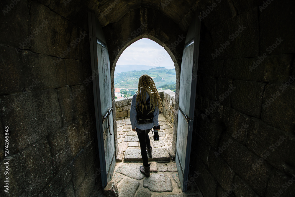 Tourist woman with a photocamera in an old abandoned fortress.