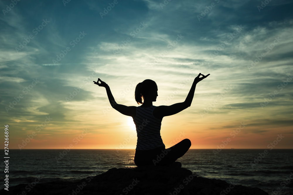 Silhouette young woman practicing yoga on the beach at sunset... Silhouette young woman practicing yoga on the beach at sunset...