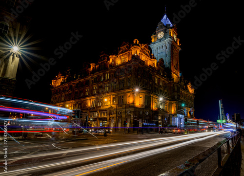 Streets of Edinburgh, Scotland, at night with light trails of street traffic on Princes Street.