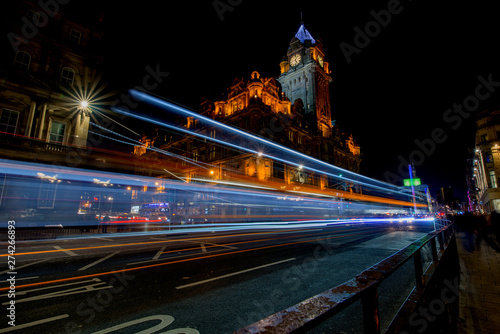 Streets of Edinburgh, Scotland, at night with light trails of street traffic on Princes Street.