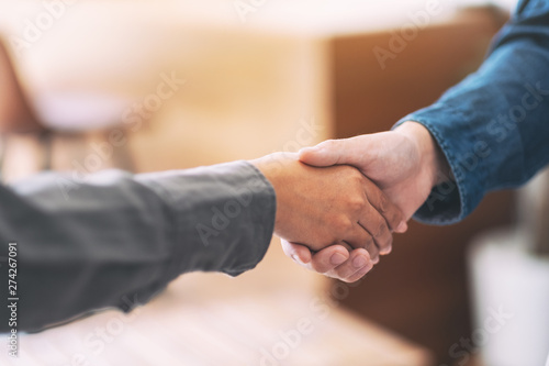 Closeup image of two businessman shaking hands after the meeting