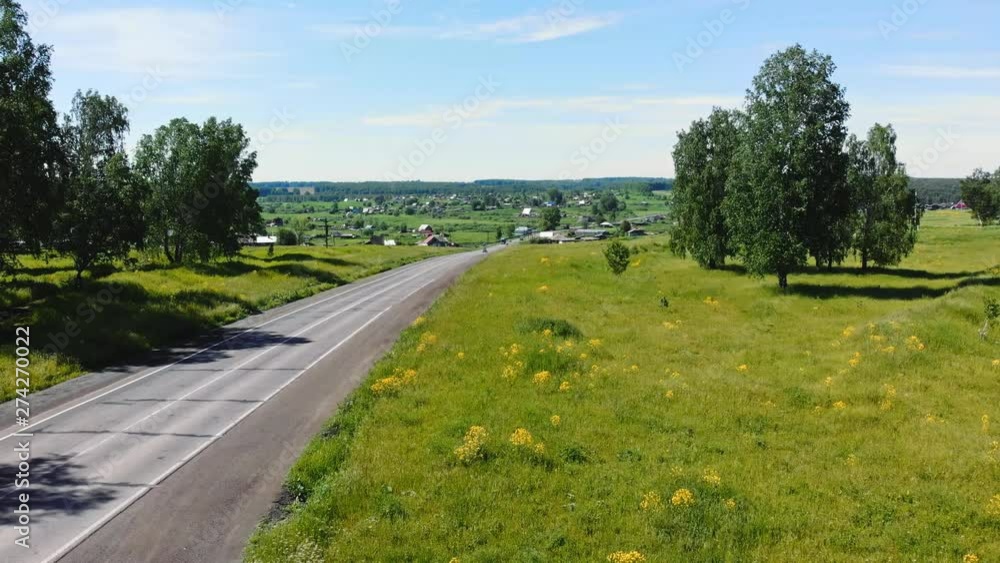 Beautiful view of the asphalt road in the countryside, with different cars passing through it, on bright summer day. Beautiful view of the asphalt road in the countryside, with different cars passing through it, on bright summer day.
