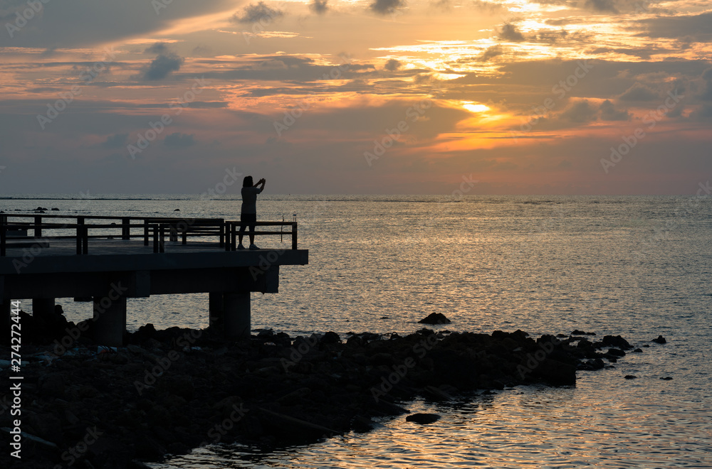 Old women standing exercise on morning sunrise on public pier Old women standing exercise on morning sunrise on public pier