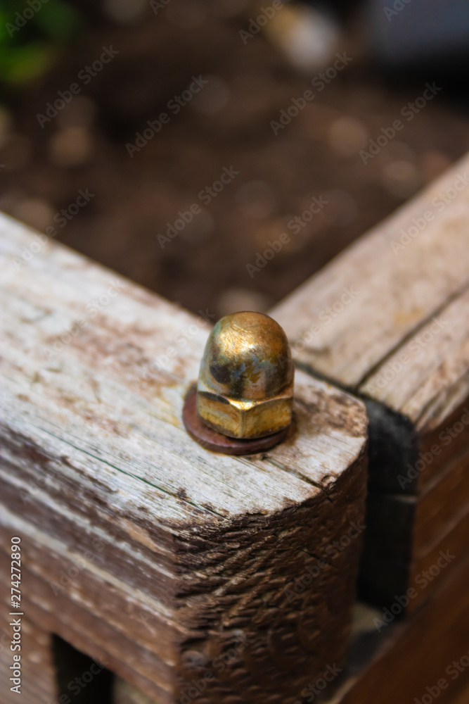 Metal bolt connecting the two parts of the wooden box in the garden closeup - Image Metal bolt connecting the two parts of the wooden box in the garden closeup - Image