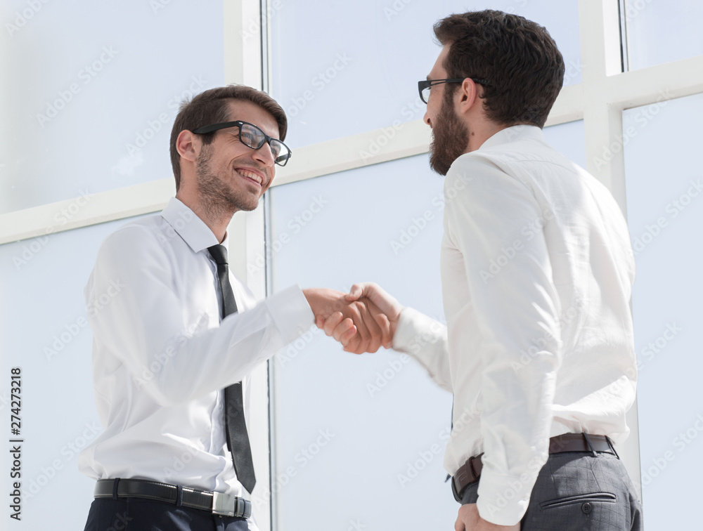 cheerful colleagues shaking hands with each other. cheerful colleagues shaking hands with each other.