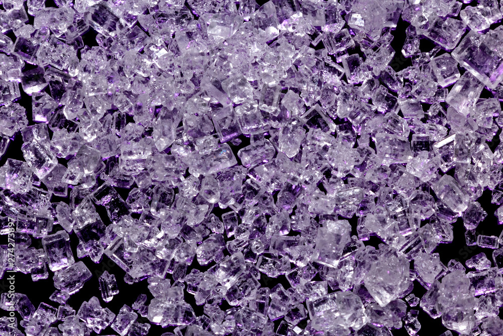 White sugar crystals on a dark violet background