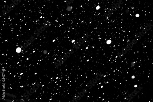 falling snow on a black background, snowfall at night, white chaotic spots on a black background