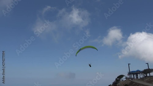 1700 m Babadag mountain peak, Fethiye, Turkey - 12th of June 2019: 4K Parachutist glides above the jumping point in the early morning photo